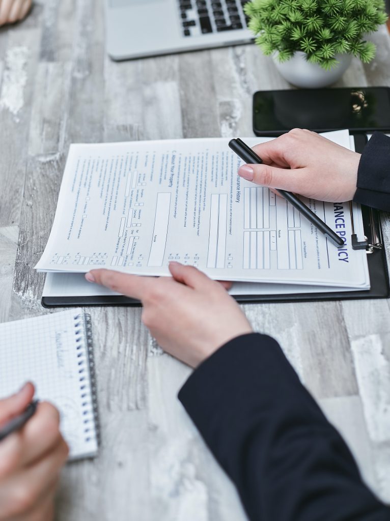 Two people reviewing and signing documents at a desk.